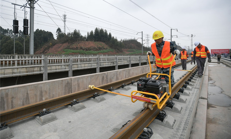 中鐵四局的建設者在四川省樂山市境內進行鋪軌作業。（新華社記者 薛玉斌 攝）