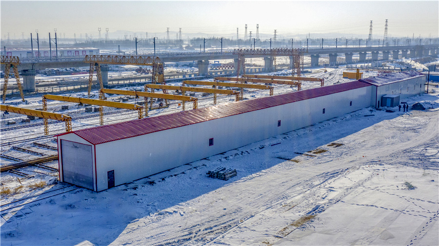 原本10個月的工期壓縮成了8個月，為確保鋪軌節點如期實現，項目部用空間換時間，通過增加工作面，見縫插針地分段鋪設，同時增加人員和設備投入，先后調撥鋪軌機3臺、移動閃光焊機3臺、機車15臺、路用平板130輛、大型養路機械8臺、道砟車60輛、吊車12臺，施工旺季1000人以上。通過優化資源配置，項目部創造了佳木斯至雙鴨山段大坡道左線日鋪軌7公里、提前23天鋪通的施工紀錄，為牡佳客專按時開通打下堅實的基礎。圖為機車恒溫庫。