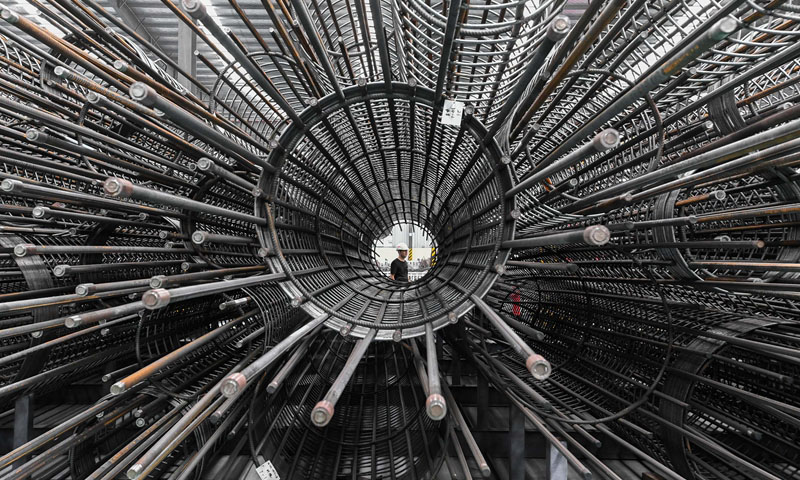 圖為9月20日，工人從中國鐵建華南建設有限公司番禺鋼材加工中心鋼筋籠成品倉庫經過。（新華社記者 劉大偉 攝）