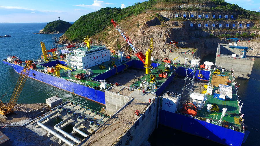 深中通道海底隧道部分是世界首例雙向八車道鋼殼海底沉管隧道，E2管節為首個標準管節，長165米，寬46米，高10.6米，重約7.7萬噸。比不久前完成安裝的E1管節比41.5米、重量超出2萬噸。標準管節E2在施工工藝、安裝條件等方面面臨多個“第一次”：為保證作業安全，中交集團所屬中交一航局科研團隊對E2管節與一體船的連接進行重新核算。圖為施工現場。