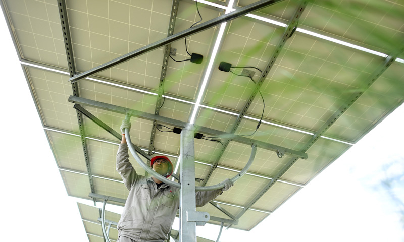 圖為7月8日，在青海省海南藏族自治州共和縣，大唐青海公司新能源分公司工作人員許源在光伏電站內調整光伏電池板角度。（新華社記者 張宏祥 攝）