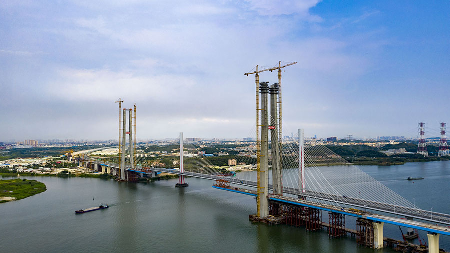 日前，由中國鐵建所屬中鐵十一局承建的粵港澳大灣區重點工程——廣州南沙港鐵路跨西江斜拉橋 156 號主塔順利封頂。至此，該橋兩座主塔全部封頂，正加快進行上部結構施工。圖為建設中的南沙港鐵路跨西江斜拉橋。（金偉 攝）
