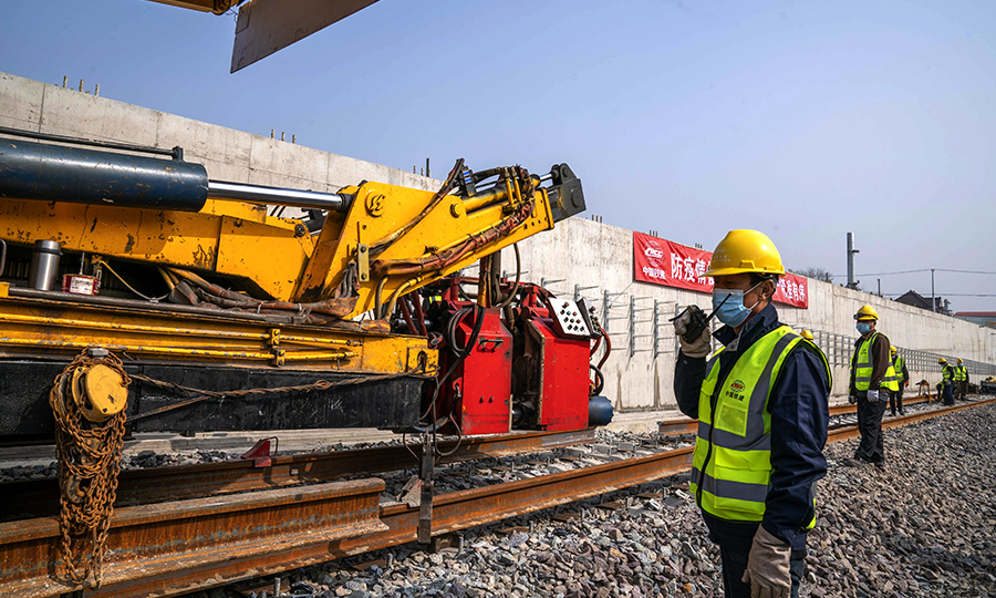 為確保疫情防控和復工復產穩步推進，中國鐵建所屬中鐵二十四局上海地鐵15號線項目部強化施工現場科學管理，優化施工工序，錯峰、分工點、分區段進行施工生產，要求施工現場做到“四必須”：入場必須測體溫、必須戴口罩、必須實名登記、工前所有器具和機械必須消毒。圖為上海地鐵15號線鋪軌B標工人師傅正在焊軌對位作業指揮。