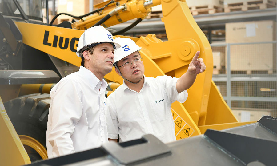  圖為近日，在巴西圣保羅，柳工巴西工廠中巴管理人員在裝配線了解設備裝配情況。