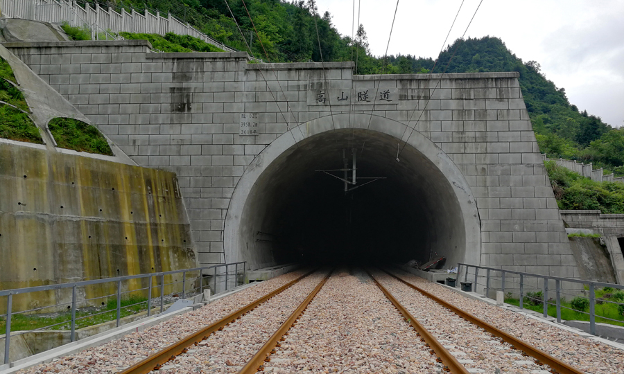 在全長3958米的高山隧道施工中，中國鐵建建設者采用平導迂回繞行等措施，取得了《穿越巨型溶洞的回填技術和施工方法》等10多項技術；以標準化管理為核心，采用“多站點”管理模式，咸豐站、來鳳站、龍山北站和桑植站4個站房在全線成為精品和樣板。圖為中鐵十四局承建的黔張常鐵路高山隧道。（李楊 攝）