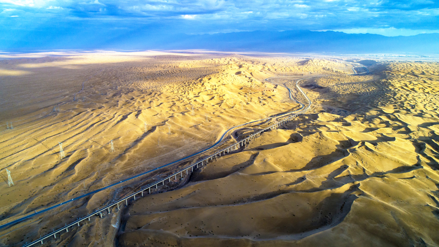 敦格鐵路北起甘肅省敦煌市敦煌站，南至青海省格爾木市格爾木站，全長616.79公里，其中新建線路509.02公里，設計時速120公里，是國鐵I級電氣化單線鐵路。圖為沙山溝特大橋高空俯拍。（金偉 攝）