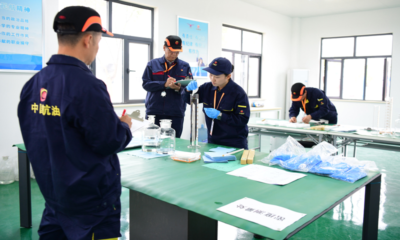 本次大賽實操考試分為計量器具選擇、罐內油品計量、數據處理、案例分析四個模塊。圖為中國民航航空油料計量統計員職業技能大賽油品密度測量考試現場。 