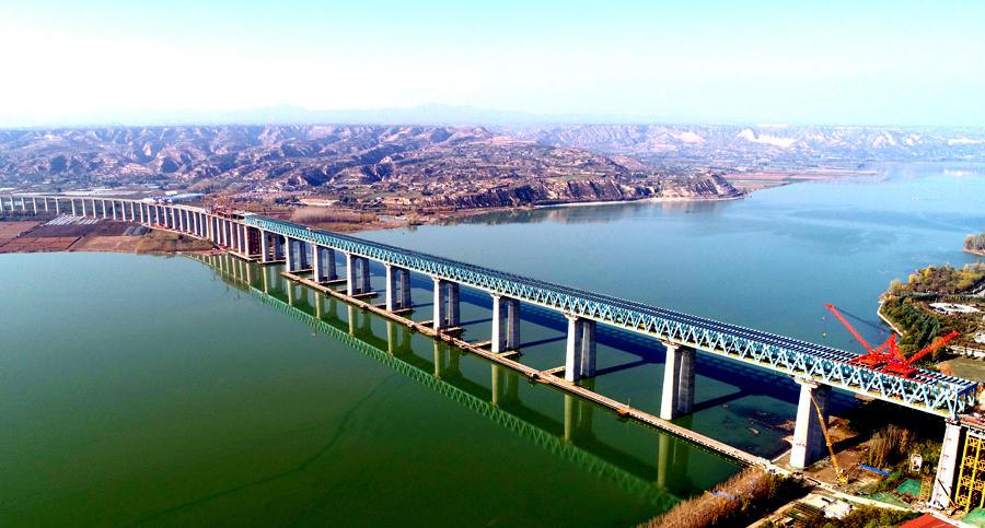 作為溝通“長江經濟帶”與“絲綢之路經濟帶”的重要干線，浩吉鐵路跨越數十條高速公路，穿越和連接20余條鐵路干線，第一次集疏運系統同步規劃和建設，銜接了沿線眾多煤炭基地和輸出入線路，豐富了這條能源大動脈的“毛細血管”，解決了鐵路運輸前后“一公里”難題。圖為中國鐵建大橋局承建浩吉鐵路三門峽黃河公鐵兩用大橋。
