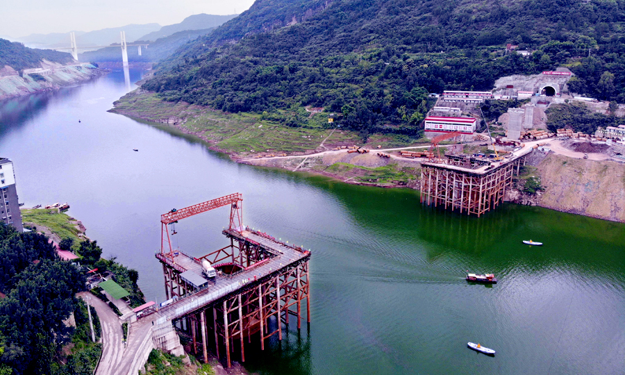 彭溪河多線特大橋位于重慶市云陽縣黃石鎮，由中國鐵建所屬中鐵十一局集團承建，大橋跨越長江一級支流彭溪河，橋長741.6米，共14跨。其10號和11號兩個主墩處于河段最高水深約60米的斜巖環境里。主墩橫穿三峽三期蓄水庫區，有三級通航要求，通航水位落差達30多米。圖為無人機拍攝的彭溪河多線特大橋施工現場。（劉興敏 攝）
