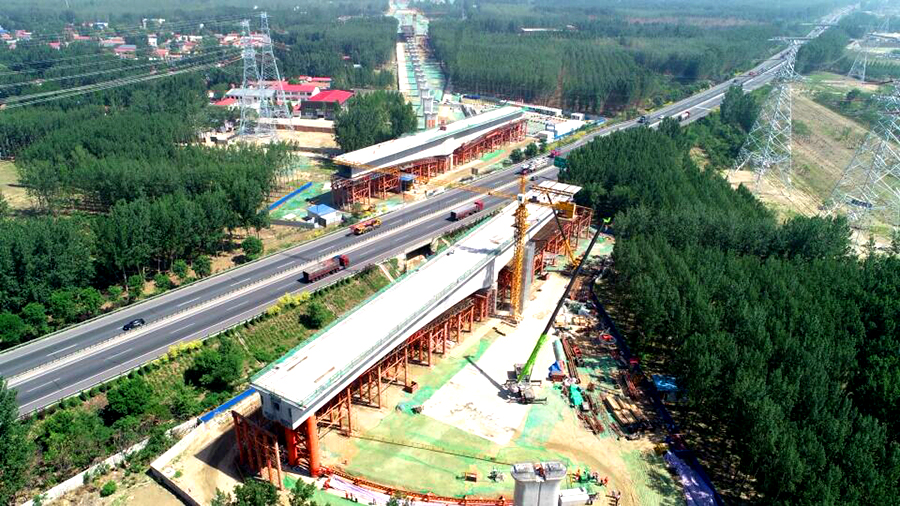 5月25日凌晨5時，經過一夜的奮戰，京雄城際鐵路重難點控制工程——固安特大橋跨廊涿高速公路72+128+72m墩頂不平衡轉體連續梁成功完成轉體，這是京雄城際鐵路建設取得的突破性建設成果。圖為轉體前連續梁在高速公路兩側分節段澆筑。