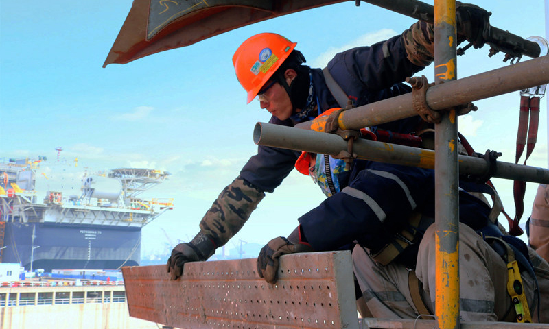 殼牌企鵝FPSO（浮式生產儲卸油裝置）是中國海所屬油海油工程公司承攬的第一個殼牌FPSO項目，目前已進入空間建造作業趕工階段。圖為3月10日，該項目船體建造現場，中國海油高空作業人員如同高空“衛士”，正在全力搭建安全作業平臺。