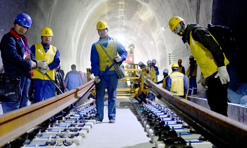據介紹，拉林鐵路路基、橋梁為有砟軌道，鋪軌采取先鋪短軌排再換長鋼軌的換鋪法，香嘎山隧道是拉林鐵路首次采用長鋼軌鋪設的隧道。圖為工作人員在香嘎山隧道鋪設長鋼軌。