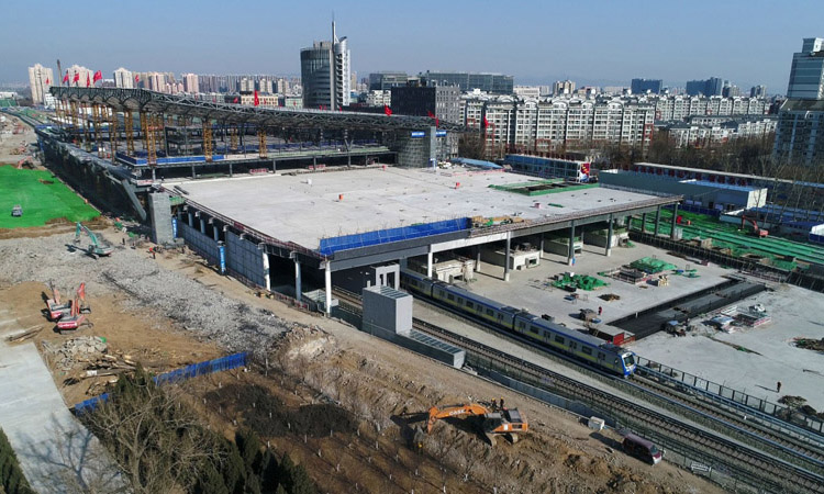 日前，北京地鐵13號線在上地站與西二旗站之間改線成功，由京張高鐵清河站站房外轉入站房內運行。圖為2月20日，地鐵列車通過建設中的京張高鐵清河站。新華社發（馮凱 攝）