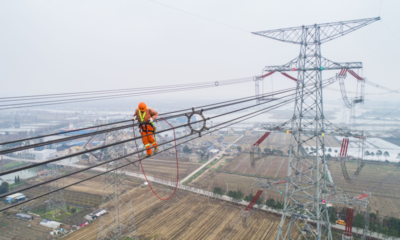 本次改接工程將有效提升特高壓線路運行可靠性，確保華東地區特高壓主干網架輸電安全，為長三角一體化戰略貢獻能源力量。圖為2月1日，施工人員正在改接工程現場進行走線，巡查特高壓線路。（新華社記者 徐昱 攝）