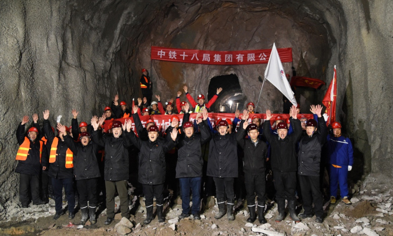 綜合管廊南起佛峪口水庫，北至延慶賽區核心區，為延慶賽區造雪用水、生活用水、再生水、電力、電信及有線電視等硬件接入提供通道。圖為1月7日，建設者們在管廊隧道貫通處慶祝。新華社發（任超 攝）