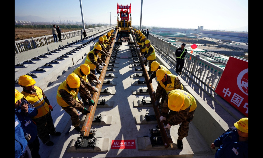 京張高鐵是國家重點建設項目，是2022年北京冬奧會的重要交通保障線。京張高鐵全長174公里，建成后，乘高鐵從北京到張家口的時間將縮短到50分鐘，對于助力奧運、促進京津冀一體化發展、連接西部都具有十分重要的戰略意義。圖為11月1日，在京張高鐵河北懷來段鋪軌現場，中鐵三局的工人鋪下京張高鐵全線第一節軌排。（新華社記者 楊世堯 攝）