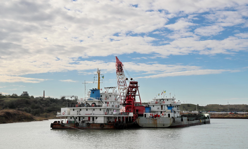 這是2017年10月12日，一組由駁船、運泥船和抓斗式疏浚船組成的清淤單元在烏克蘭敖德薩州南方港施工。由中國港灣工程有限責任公司承攬，中國交建天津航道局有限公司承建的烏克蘭南方港糧食碼頭疏浚工程2018年1月30日舉行竣工簽字儀式。南方港疏浚項目解決了該港口被淤泥阻塞多年的困擾，對烏克蘭進一步擴大糧食出口具有戰略意義。（新華社記者陳俊鋒 攝）