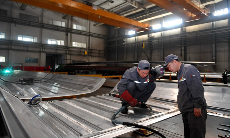 4月27日，周晶輝（右）與徒弟臧鐵軍一起研究改進高鐵車體焊接工藝。（新華社記者 張楠 攝）