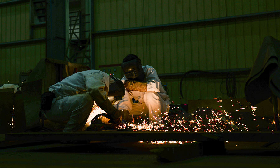 近日，中核華興一線鉚工陳喜文與田勇軍正在去除引弧板作業。（范錦紅 攝）