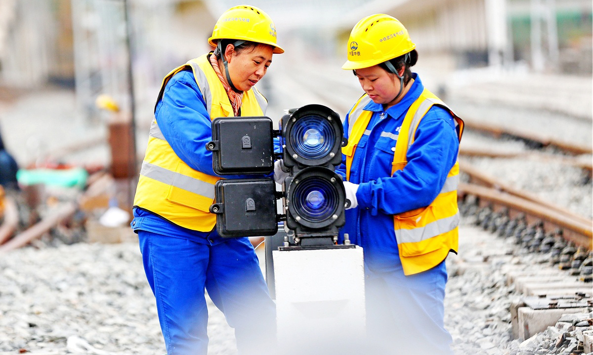 在施工現場，20歲的突擊隊隊員張玉倩正在專心致志地進行箱盒配線作業，分線、穿線……動作流暢連貫，猶如繡娘在穿針引線。突擊隊隊員平均年齡29歲，張玉倩是年齡最小的姑娘。她們擔負著管段內9個車站、9座信號樓的施工任務。為縮短工期，提高效率，隊員們打破常規，創新配線工藝，得到了專家的一致認可。圖為信號燈配線。