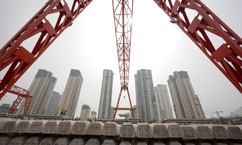 6月1日，在和（順）邢（臺）鐵路鋪軌基地，中鐵六局施工人員駕駛鋪軌機開始鋪設鐵軌，這標志著和邢鐵路進入鋪軌施工階段。圖為中鐵六局的建設者在搬運軌枕。（新華社記者 駱學峰 攝）