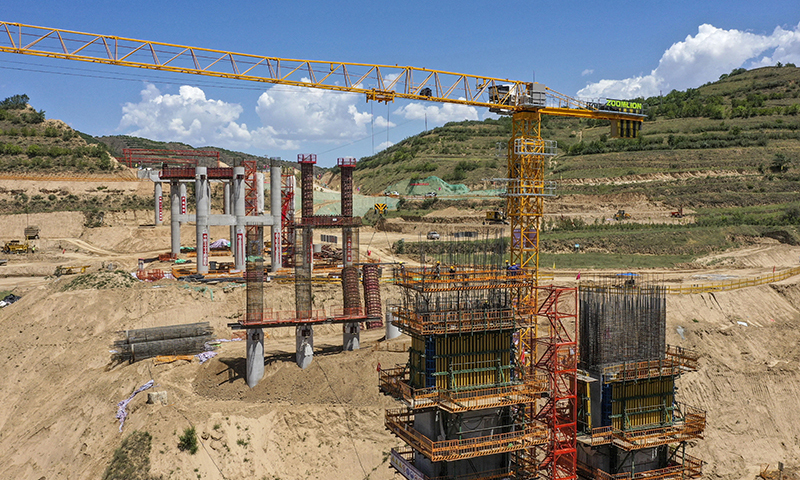 近日，在銀（川）昆（明）高速寧夏境內的LJ12-1標段，來自中鐵二十一局的建設者們正在加緊施工。銀昆高速寧夏段項目起于吳忠市太陽山開發區，經過吳忠市利通區、紅寺堡區、同心縣，中衛市海原縣等，止于固原市彭陽縣的寧夏與甘肅交界處，全長237公里。圖為建設工人在銀昆高速寧夏境內的LJ12-1標段的虎岔大橋上施工作業（無人機照片）。新華社記者 馮開華 攝