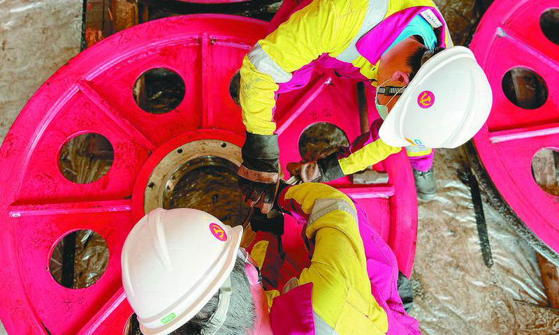 圖為機械師段慧超和裝備維修謝小金正在協作配合拆檢游車滑輪軸承端蓋。