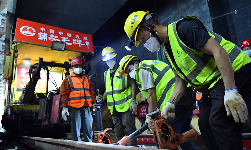近日，鄭（州）許（昌）市域鐵路鄭州段軌道貫通。鄭許市域鐵路工程又稱鄭州機場至許昌市城市軌道交通工程，是一條連接鄭州市與許昌市的城市軌道交通系統，全長67.13公里，設計時速120公里。圖為中鐵五局工人在鄭許市域鐵路鄭州段進行打磨軌道作業。（新華社記者 李嘉南 攝）