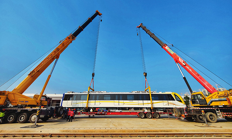 全長50.34公里的地鐵14號線是深圳東部首條地鐵快線，連接福田中心區、羅湖、大運新城、坪山中心等地區。圖為施工人員將深圳地鐵14號線首列電客車吊裝到軌道上。（新華社記者 劉大偉 攝）
