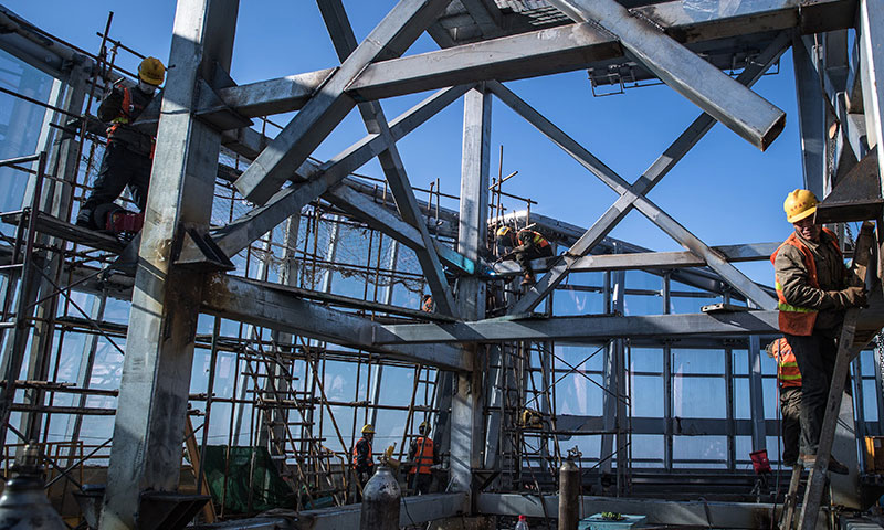 這些建設者中有不少參與過武漢火神山、雷神山醫院的建設。圖為11月15日，中建三局二公司工人在武漢綠地中心項目建設現場近500米的高空施工。（新華社記者 肖藝九 攝）