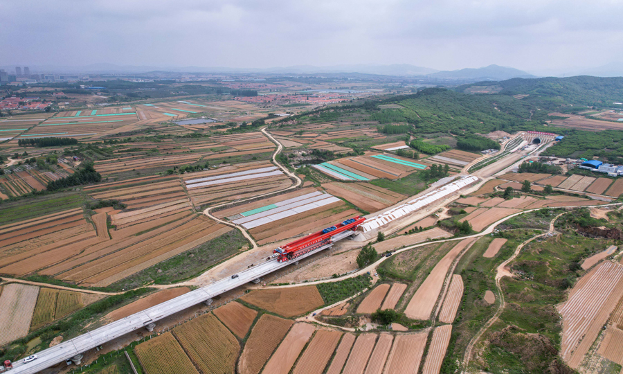 6月8日，隨著鋸河特大橋62號墩至63號墩的箱梁落定，中國中鐵旗下中鐵四局承建萊榮高鐵乳山段大里程方向306榀預制箱梁全部架設完成。該箱梁每榀長32.6米、寬12.6米、高3米，重達790.3噸。圖為項目建設現場。