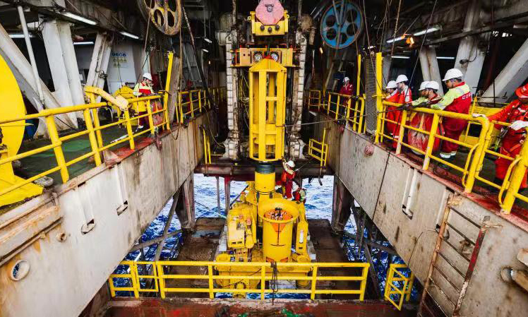 水下采油樹是海洋油氣水下生產系統的核心組成部分，也是構建水下油氣井生產管柱的基礎，該裝備重量達到55噸，由超過2500個零部件組成，具備安全隔離儲油層、保證井下作業安全等功能，可有效降低項目成本。圖為今年5月份，國產深水水下采油樹在月池就位，中國海油工程師正在安裝采油樹保護框架導向樁。