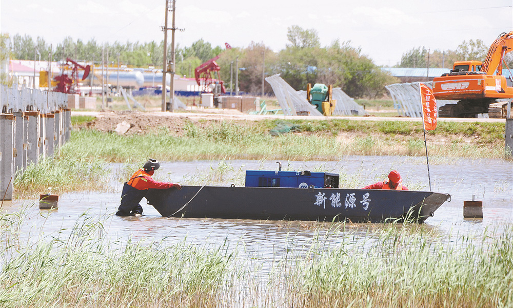 今后，大慶油田將進一步加快新能源產業發展布局，為促進國家綠色低碳發展貢獻力量。圖為工人自制“新能源號”實驗船保障施工。 