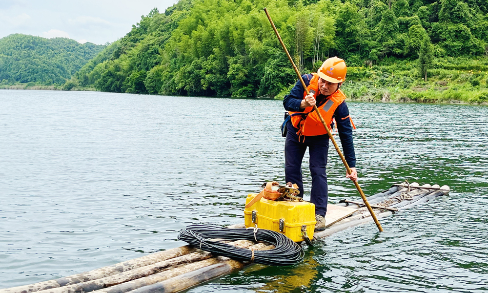 為解決網絡障礙問題，中國電信安徽祁門分公司維護人員撐竹排加步行，趕往用戶家中維修。