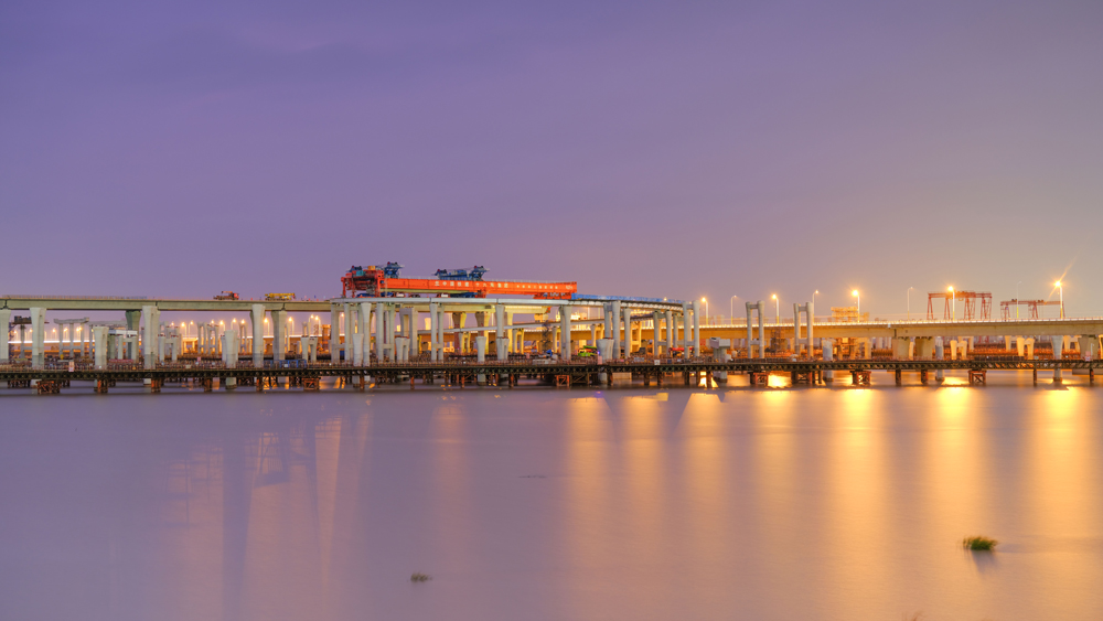 11月3日凌晨，由中國鐵建所屬中鐵十六局負責架梁施工的亞洲最大海上互通主線橋——杭甬高速復線寧波一期工程濱?；ネㄖ骶€橋成功上跨甬舟高速金塘大橋。圖為“越海號”架橋機架梁施工現場。