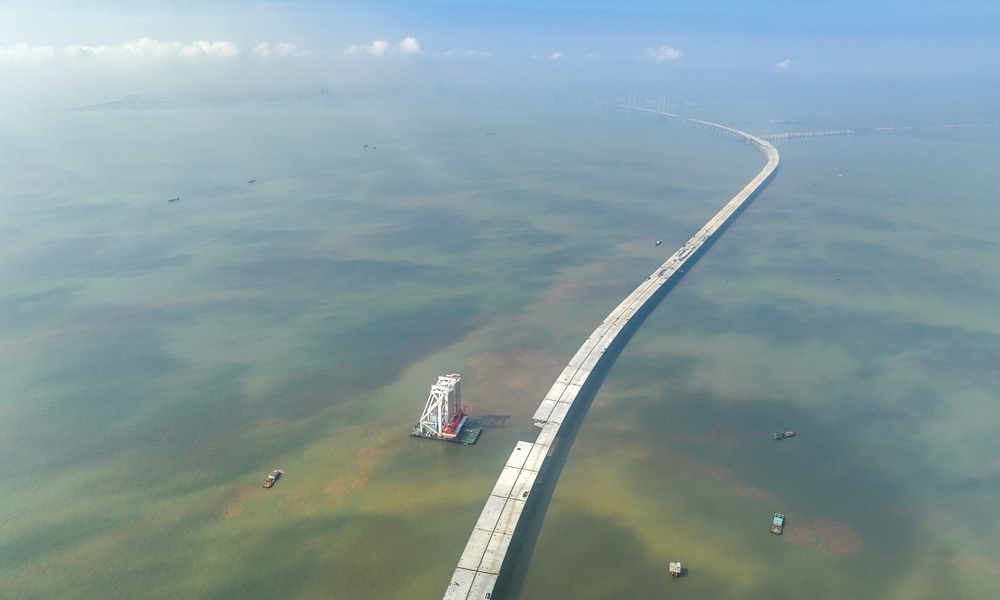 深中通道是集“橋、島、隧、水下互通”于一體的跨海集群工程，全長約24公里。其中海上非通航孔橋共設293片混凝土梁和鋼箱梁。梁體種類多，噸位重，架設精度要求高。本次架設混凝土梁單片長60米、寬20米、高3.5米，重約2800噸，相當于1800輛小轎車的重量，梁體頂部面積相當于3個標準籃球場。圖為11月10日拍攝的深中通道施工現場。