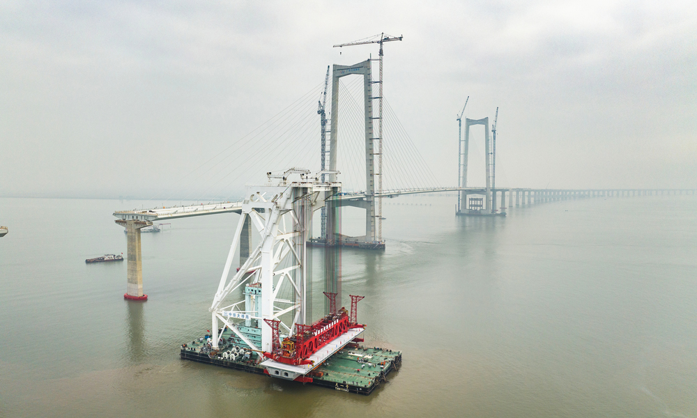 面對項目海域箱梁架設具有運輸線路長、穿越航道多、箱梁噸位重，架設精度要求高等難點，中鐵大橋局采用國內首創單體船型結構、全電力推進的海上架梁施工專用起重船“天一號”開展架設施工。圖為11月10日拍攝的深中通道施工現場。