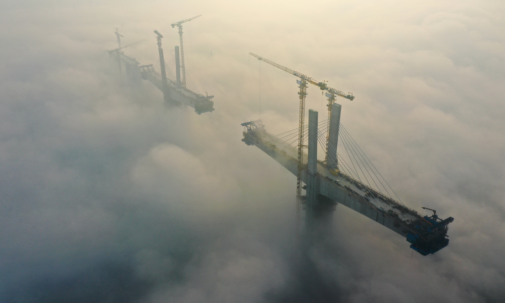 11月15日，中鐵四局建設者在100余米的高空進行斜拉索掛索及懸臂節段掛籃懸澆作業。