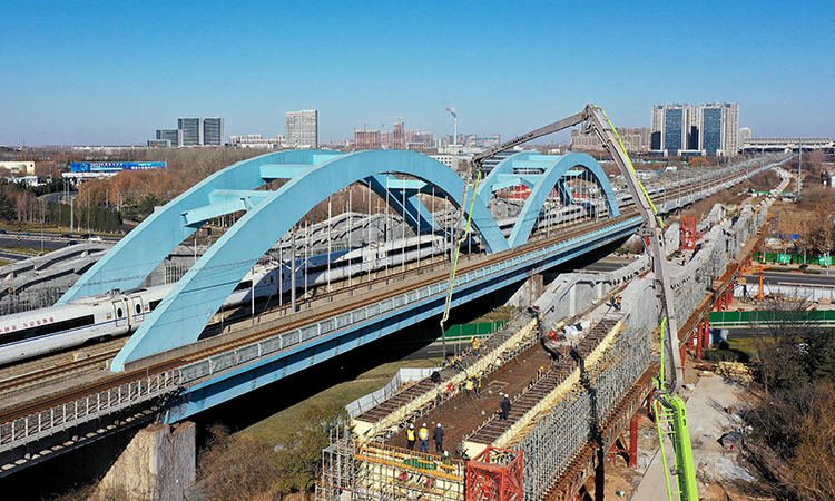 12月22日，濟（南）鄭（州）高鐵跨濟南經十西路槽型梁順利合龍，為濟鄭高鐵后續架梁、鋪軌等工作奠定良好基礎。圖為中鐵十局的工作人員在對濟鄭高鐵跨濟南經十西路槽型梁進行合龍作業（無人機照片）。新華社記者 郭緒雷 攝