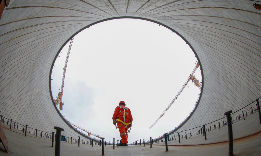 金灣“綠能港”位于廣東珠海金灣區高欄港，是珠江口西岸最大的液化天然氣接收站。走進現場，5座高65.7米、直徑94.2米的LNG（液化天然氣）儲罐矗立在青山碧海間。二期項目同時建設5座27萬立方米LNG儲罐及配套設施，已被列入國家石油天然氣基礎設施重點工程。圖為作業人員在穹頂進行安全檢查。