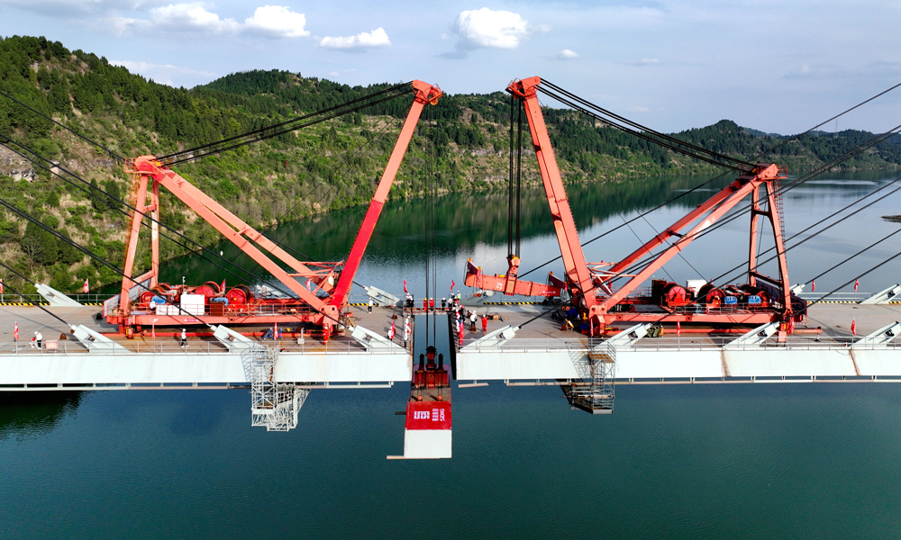 3月31日上午，隨著最后一孔鋼箱梁組件被精準架設至預定位置，標志著由蜀道集團投資建設、中國鐵建所屬鐵五院設計的漢巴南高鐵控制性工程、我國首座雙線高速鐵路高低塔混合梁斜拉橋——嘉陵江特大橋正式合龍。至此，被譽為“紅色高鐵”“出川新蜀道”的漢巴南高鐵全線控制性工程均已打通，為項目如期通車奠定了堅實基礎。圖為嘉陵江特大橋合龍現場。