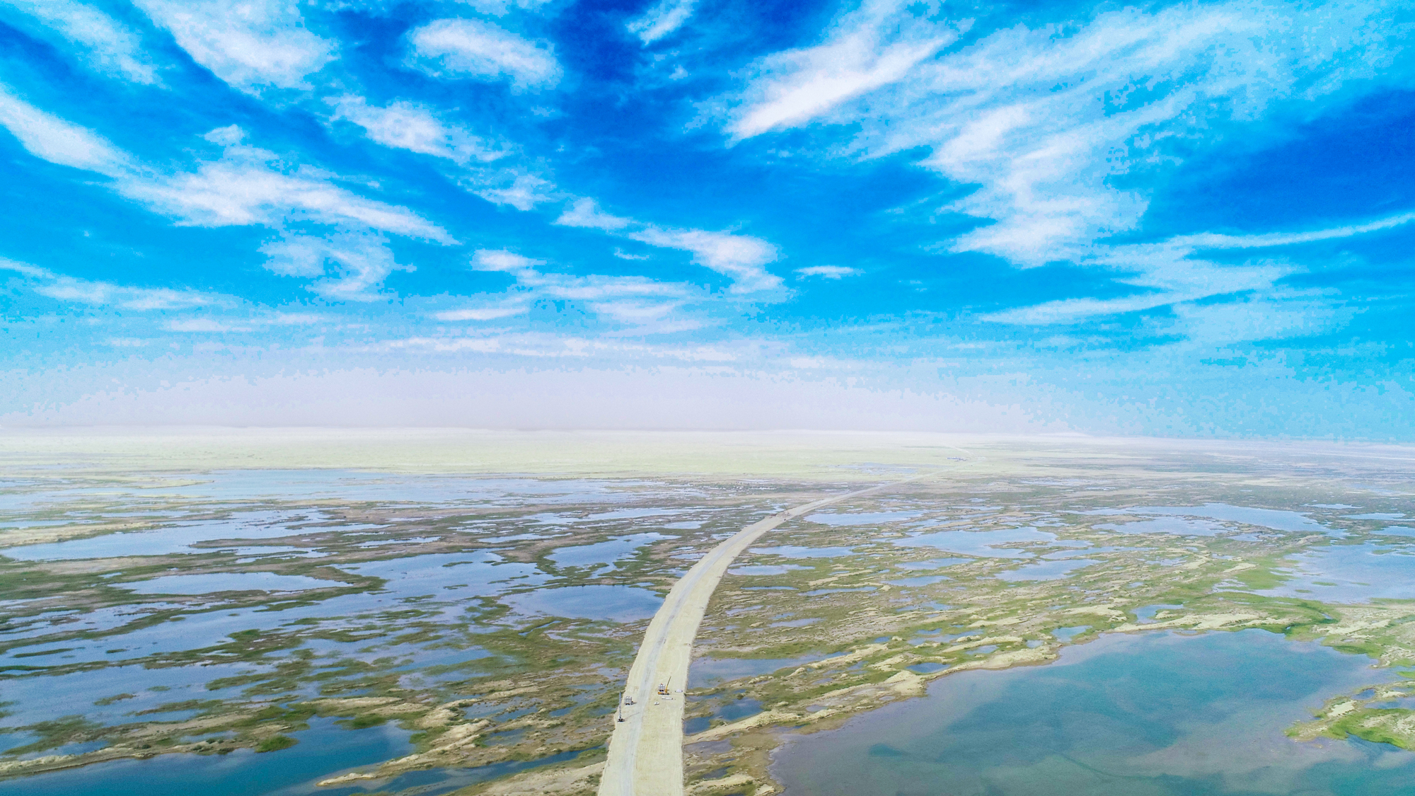 近年來，中國交建踐行綠色低碳發展理念，建設綠色工程，守護綠水青山。為保護野生動物的“樂園”——臺特瑪湖，中國交建總承包分公司新疆烏尉高速公路項目從設計源頭入手，繞道80公里外填筑路基，并為機械和車輛安裝托油盤，最大限度減少對湖區環境的影響，用實際行動加強生態環境保護。圖為項目施工現場。