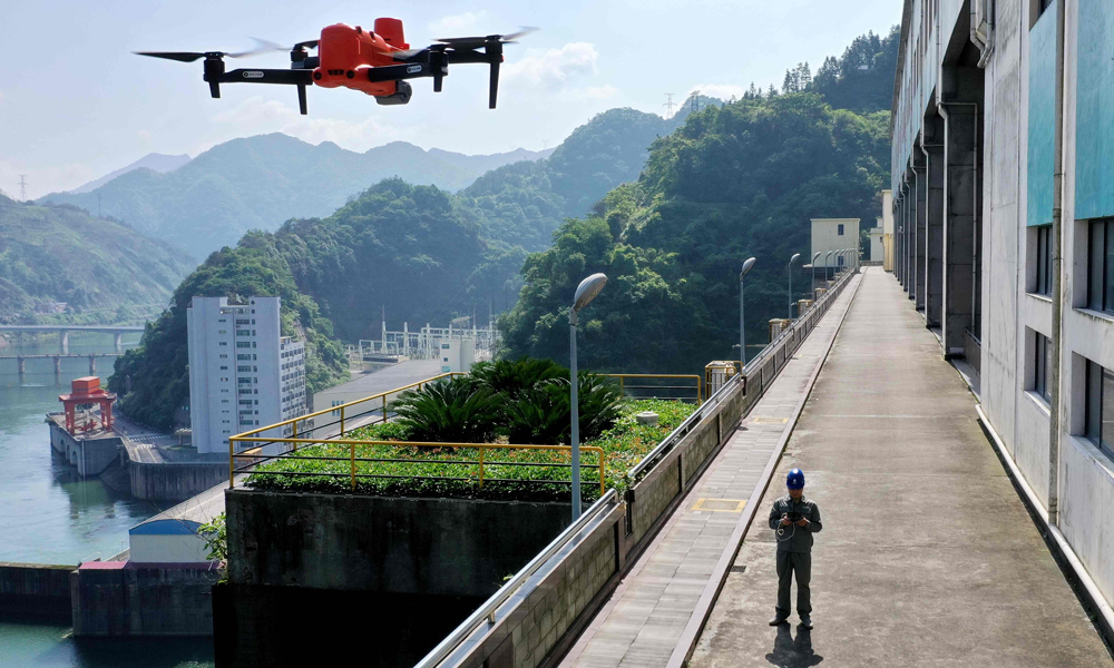 近日，國家電網湖南水電公司員工操作無人機巡查柘溪電廠水工建筑物，確保汛期設備安全。