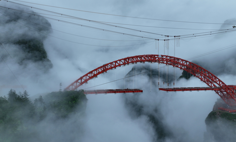 溇水河特大橋主橋為310米主跨的中下承式高低鋼桁拱橋，橋面寬31米，設計為雙向四車道，采用“纜索吊機吊裝+斜拉扣掛法懸臂法”總體方案施工。橋梁拱肋共分為50個節段，最大吊重節段約135噸。目前，大橋鋼拱已拼裝完成，正在進行鋼梁安裝，預計今年7月份完成鋼梁施工，今年年底完成整個大橋的建設。圖為近日拍攝的溇水河特大橋。楊順丕 攝