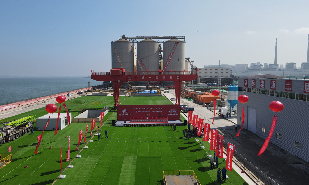 本次始發的“國信號”服務隧道盾構機開挖直徑8.18米，主機總長180米，總重1686噸，配置了伸縮式主驅動、伸縮式開挖加監視系統、泥漿循環系統、SAMSON保壓系統等一系列智能系統，還應用了同步雙液注漿、同步拼裝等多項前沿技術。主軸承配備4道外密封和3道內密封，可承受最大開挖面壓力達到1.2兆帕，以確保安全平穩掘進。同時，建設團隊根據建設條件和項目特點，設計采用高強高抗滲性的鋼筋鋼纖維混凝土管片，并通過預制箱涵特殊設計，首次在8米級盾構內實現下部結構同步施工，為工程安全高效的建設提供了技術保障。圖為始發儀式現場。