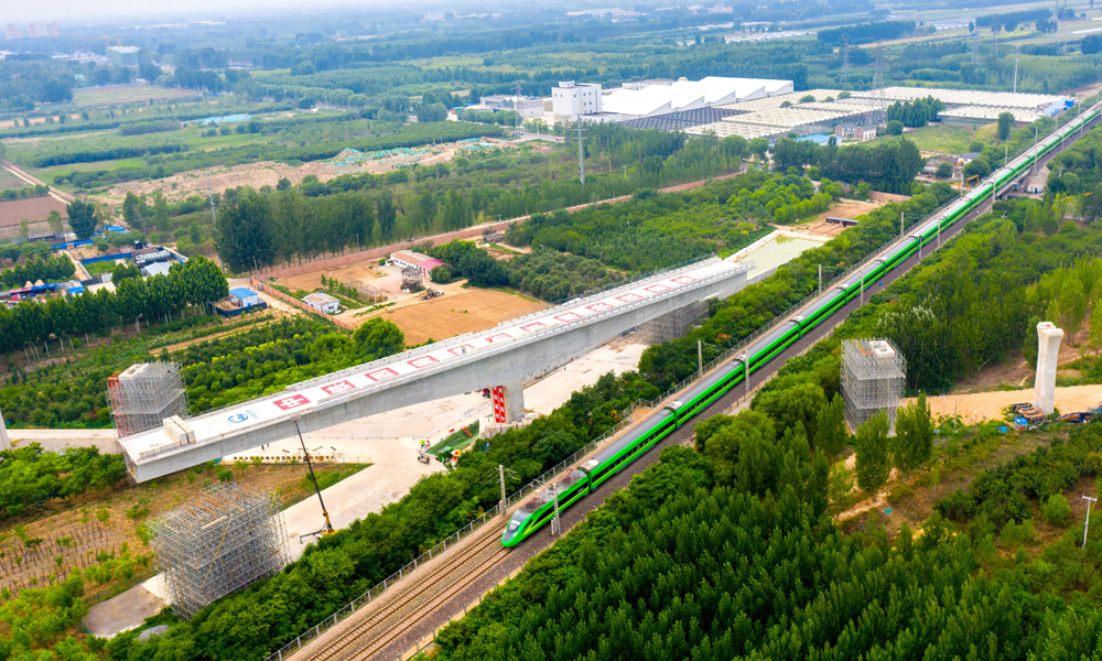 此次合龍的轉體梁重8500噸，長148.59米，轉體前于京九鐵路西側澆筑。在萬噸球鉸的牽引下，轉體梁以每分鐘1°15′度的速度順時針轉動55°66′度后到達指定位置。相比于傳統的連續梁施工，轉體施工方案具有對既有結構物干擾小、鄰近營業線施工安全更易受控等特點。圖為跨京九鐵路轉體梁轉體前航拍。