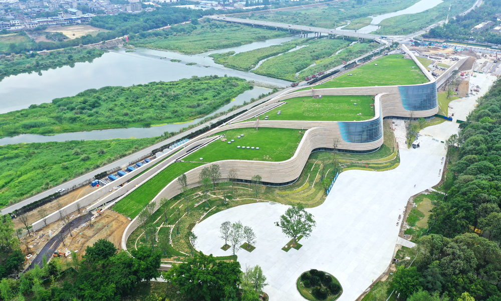 三星堆博物館新館屋頂選用了固化纖維土全種植屋面，綠植種植面積約2.7萬平方米。從空中俯瞰，整個新館與大地融為一體，實現了建筑消隱融于環境的設計初衷?？紤]到斜屋面綠化種植特點，建設團隊在建設過程中將植物纖維、有機化合物和營養物質通過微波加熱及機械壓縮形成固化土基質，用于屋面種植。這種基質土層飽水荷載小于45公斤每平方米，可以有效降低屋面覆土荷載，實現了建筑材料從原材料、生產到使用全過程的低碳化，也降低了斜屋面綠植運營養護土壤的營養流失。建設期間，項目還通過太陽能、風能利用，噪音控制、揚塵控制等系統，實現了全過程綠色建造。