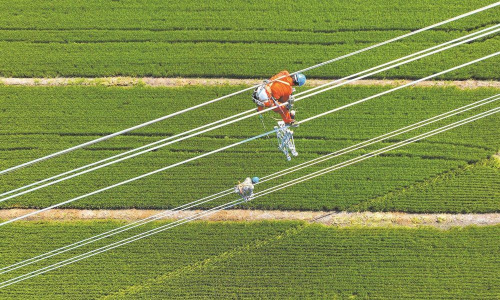 近日，國家電網各單位強化電網運行控制，加強設備運維管理，落細負荷管理措施，成功應對高溫、臺風、洪澇災害，保障電力可靠供應。圖為8月23日，國家電網江蘇送變電公司施工人員在±200千伏揚州—鎮江直流輸電線路工程現場架設導線。該工程是我國首個“交流改直流”輸電工程，投運后可增強江蘇電網過江輸電通道的送電能力，將蘇北的綠色電力送至蘇南地區。