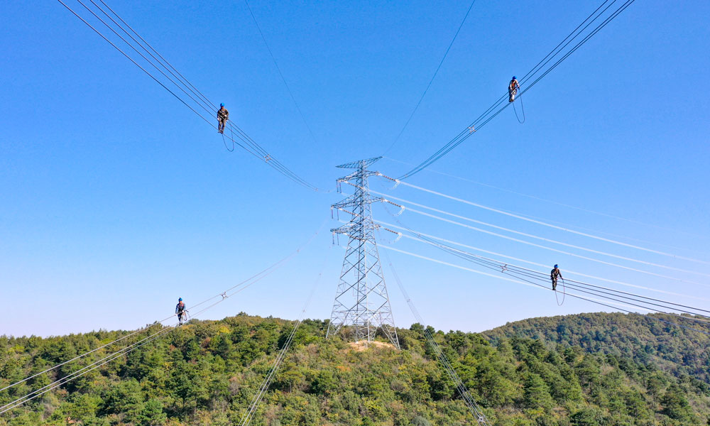 國家電網江蘇省送變電有限公司輸電人員在高空走線驗收消缺。