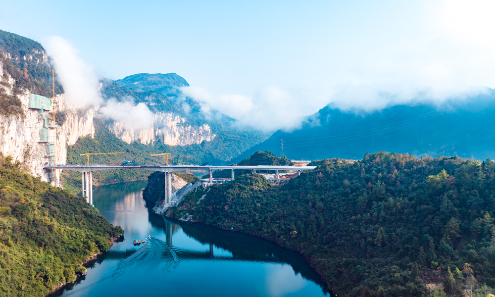 渝湘復線高速公路總里程280公里，由巴南至彭水、彭水至酉陽、武隆至道真3條路組成，平均橋隧比80%。圖為阿蓬江大橋施工現場航拍側景。